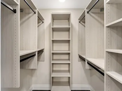 a view of walk in closet with empty racks