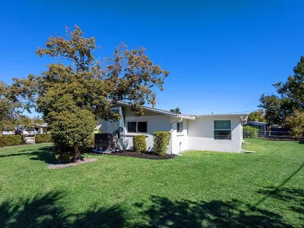 a front view of house with a garden