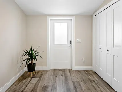 a view of a hallway with wooden floor and a potted plant