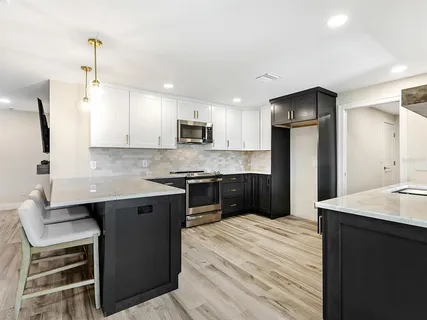 a kitchen with kitchen island a sink stainless steel appliances and cabinets