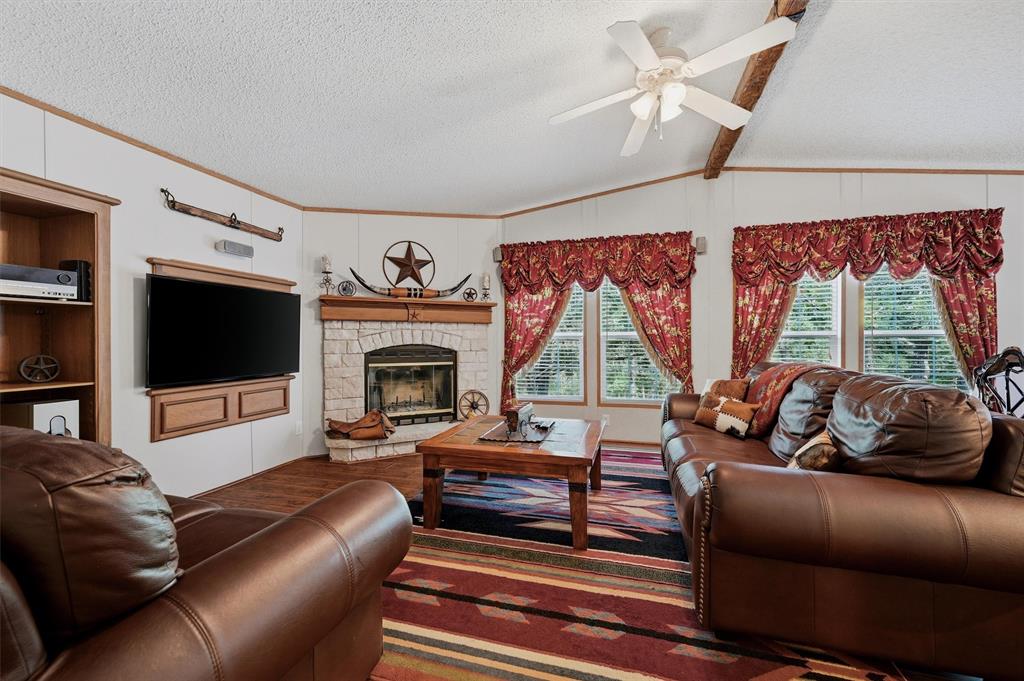 212 Sunset Road Pottsboro, TX 75076 - Photo 22 of 40 a living room with furniture a flat screen tv and a fireplace