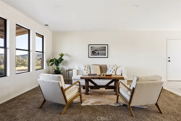 a living room with furniture and a floor to ceiling window
