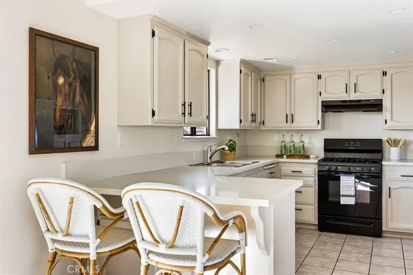 a kitchen with stainless steel appliances granite countertop grey cabinets a stove a sink and dishwasher