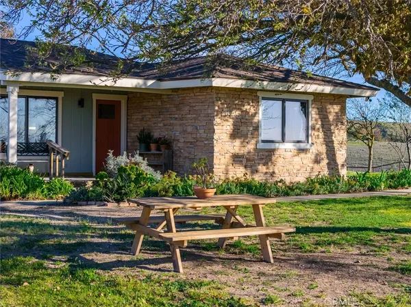 a view of a chair and table in backyard of the house