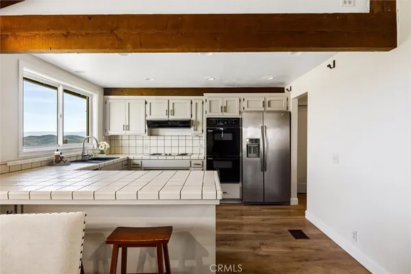 a kitchen with stainless steel appliances kitchen island granite countertop a refrigerator and a stove top oven