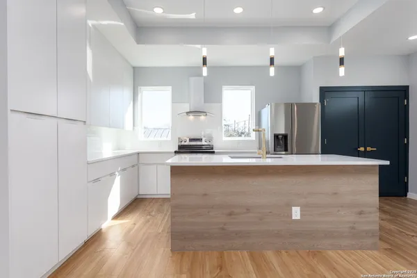 a large kitchen with kitchen island a sink stainless steel appliances and cabinets