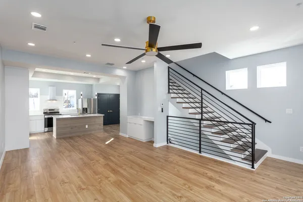 a view of open kitchen with a sink and wooden floor