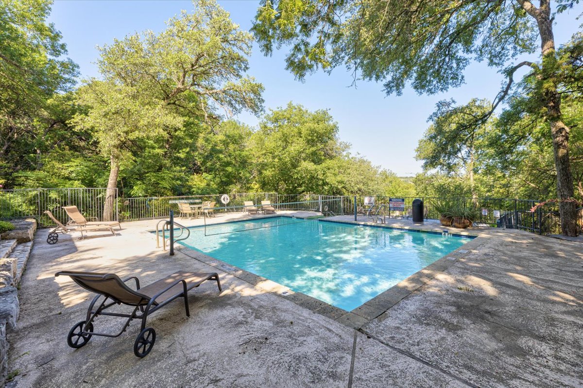 4711 Spicewood Springs Road, Unit 4222 Austin, TX 78759 - Photo 29 of 35 A private pool with lounge seating and a picturesque wooded backdrop for ultimate relaxation.