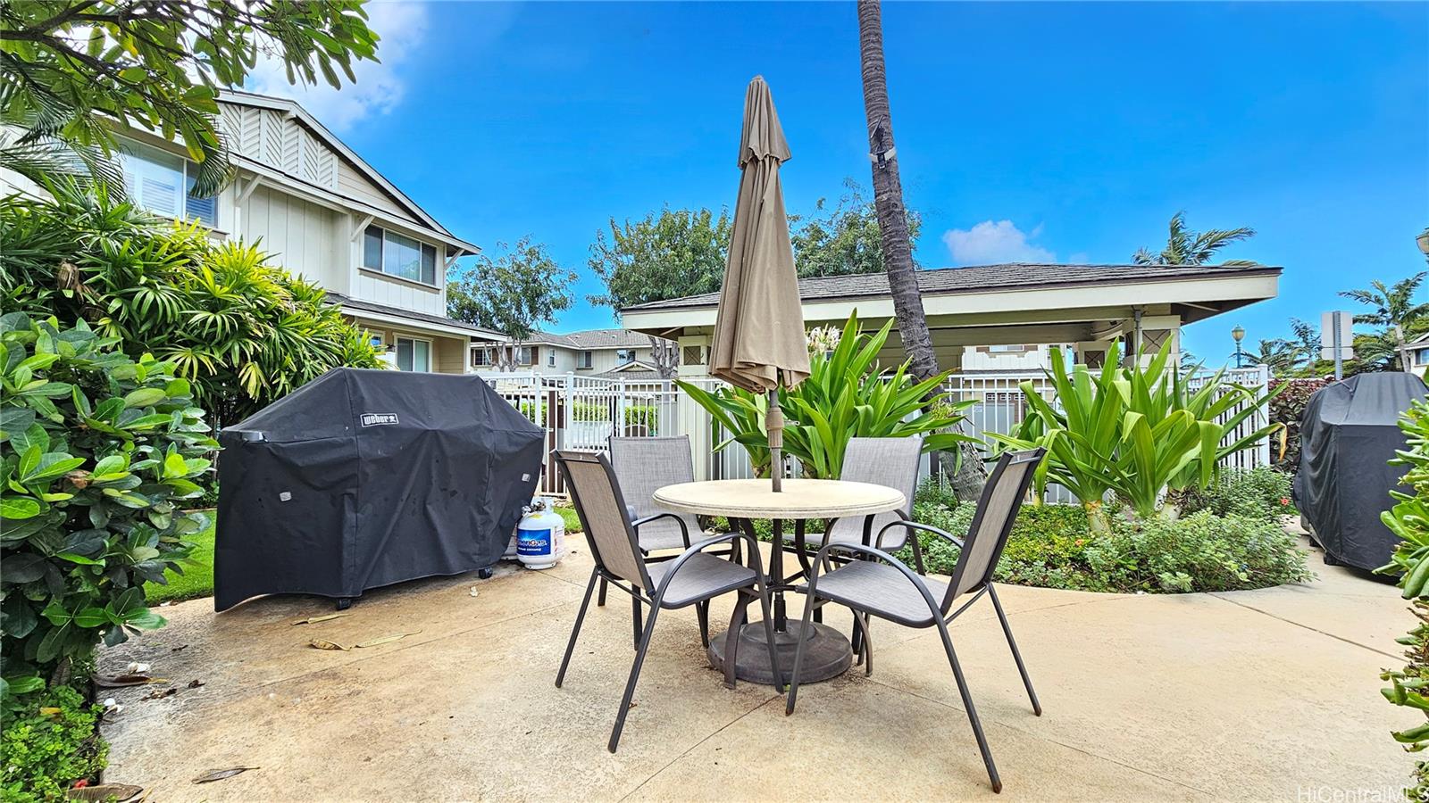92-1490 Ali'inui Drive, Unit 803 Kapolei, HI 96707 - Photo 19 of 20 a view of a chairs and table in the backyard