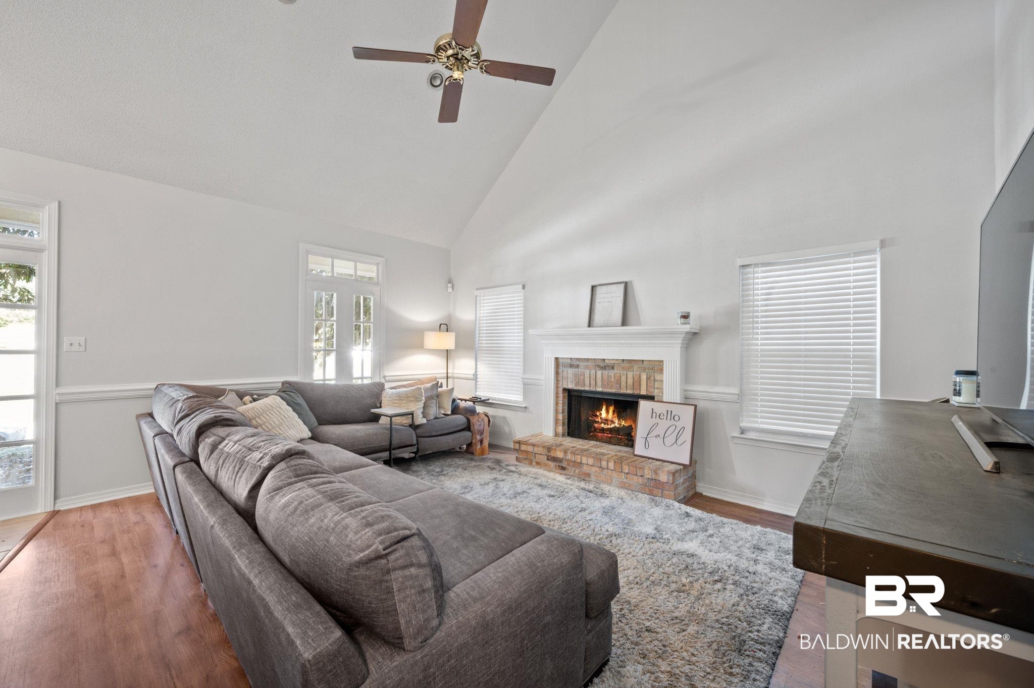 6705 Autumn Ridge Drive Mobile, AL 36695 - Photo 8 of 24 Living room with hardwood / wood-style flooring, ceiling fan, a fireplace, and high vaulted ceiling