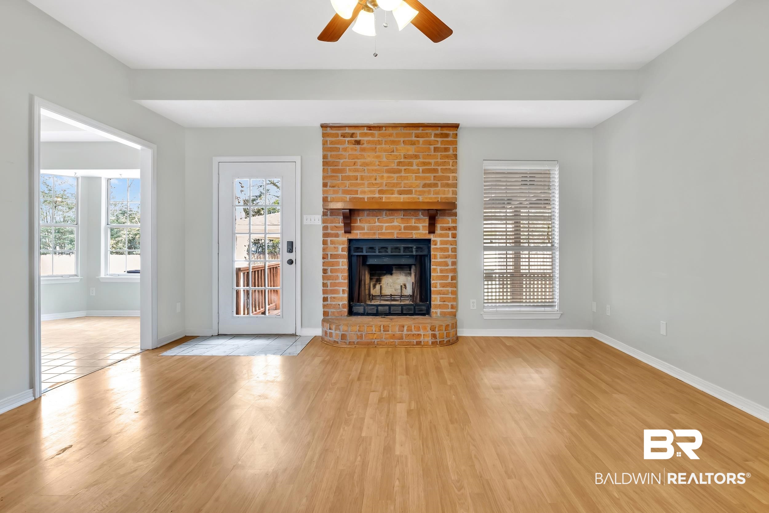 6616 Conde Court Mobile, AL 36695 - Photo 15 of 27 Unfurnished living room with baseboards, a fireplace, wood finished floors, and a ceiling fan