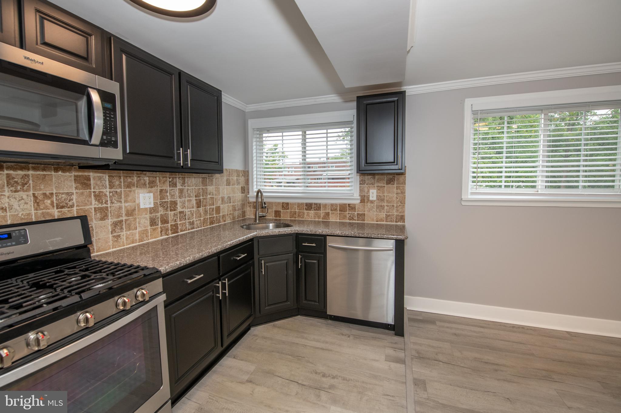 784 Bennington Road Folcroft, PA 19032 - Photo 11 of 36 a kitchen with stainless steel appliances granite countertop a stove a sink and a microwave