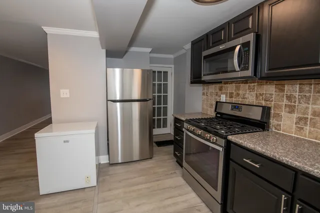 a kitchen with stainless steel appliances granite countertop a stove microwave and refrigerator