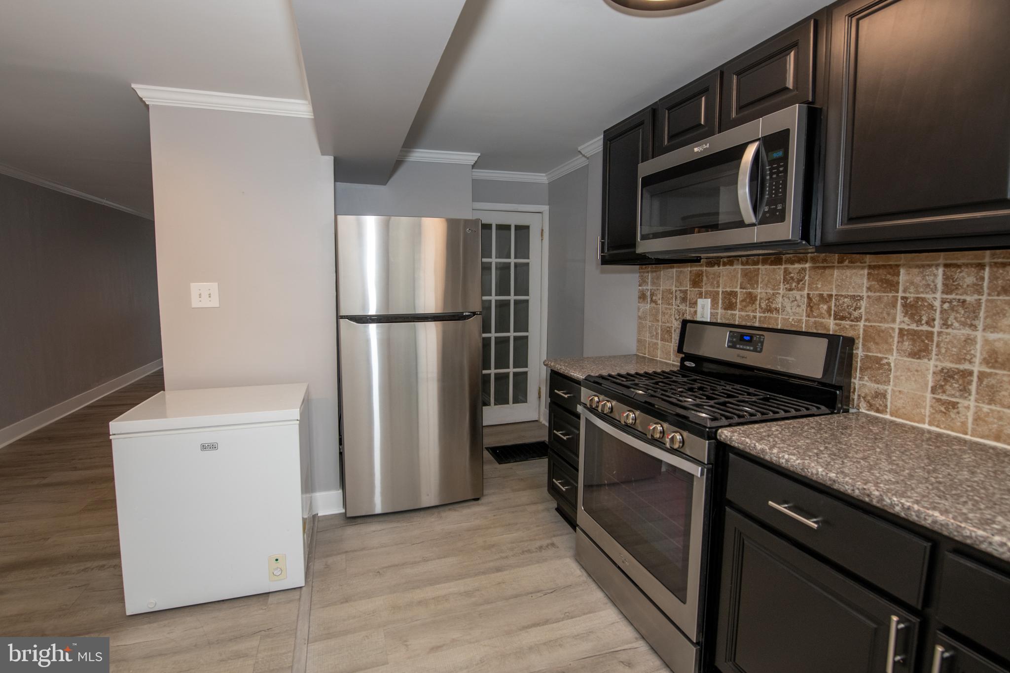 784 Bennington Road Folcroft, PA 19032 - Photo 13 of 36 a kitchen with stainless steel appliances granite countertop a stove microwave and refrigerator