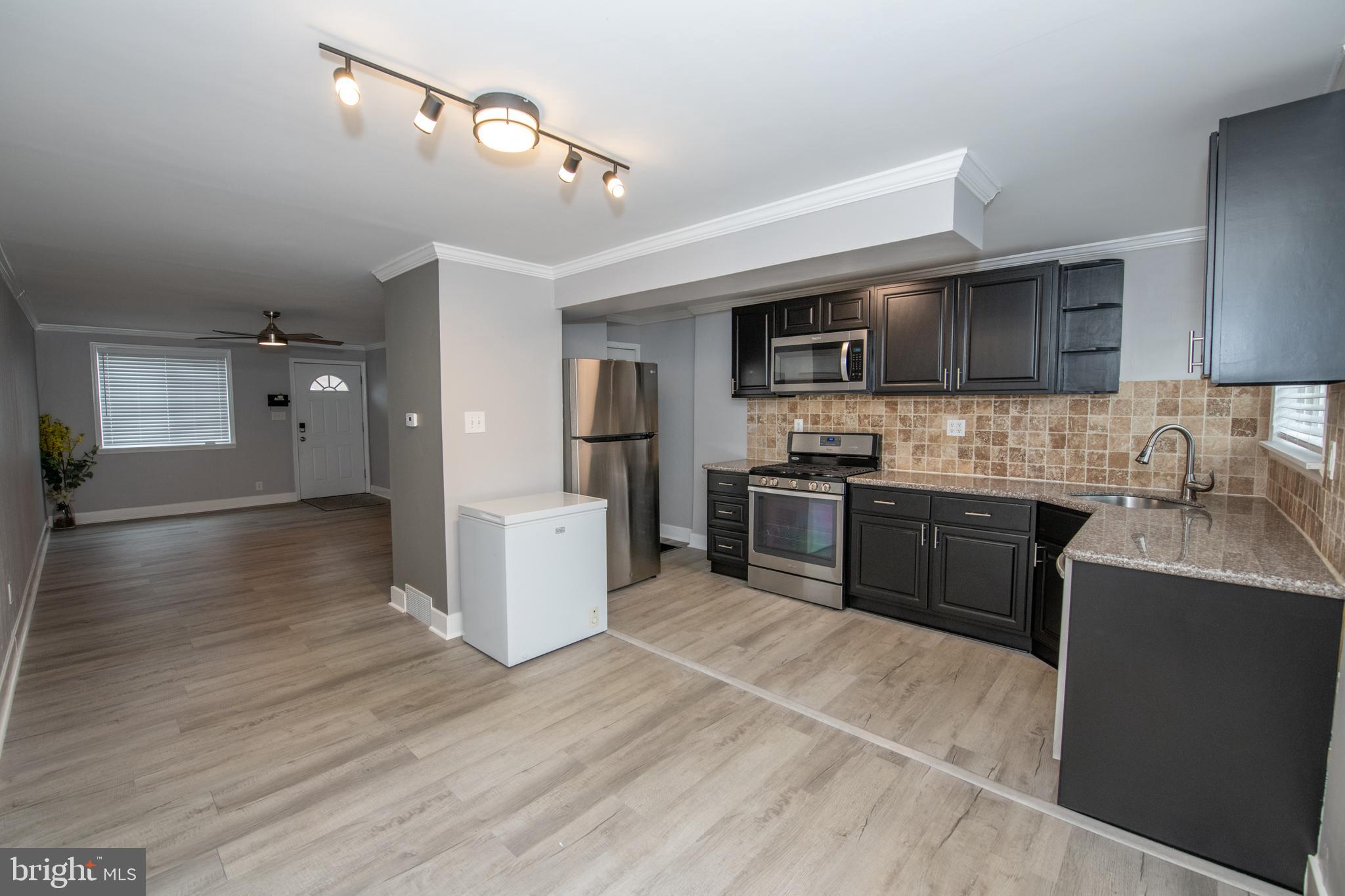 784 Bennington Road Folcroft, PA 19032 - Photo 9 of 36 a kitchen with granite countertop a stove top oven a sink dishwasher and a refrigerator