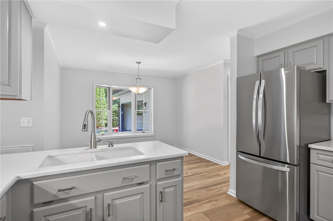 9 Lookout Lane Salem, SC 29676 - Photo 6 of 46 A well-appointed kitchen features a deep sink and gleaming stainless steel refrigerator, all set against rich wood flooring.