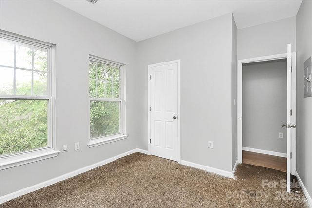 an empty room with windows and closet