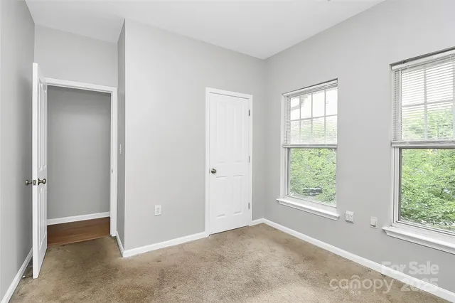 an empty room with windows and closet