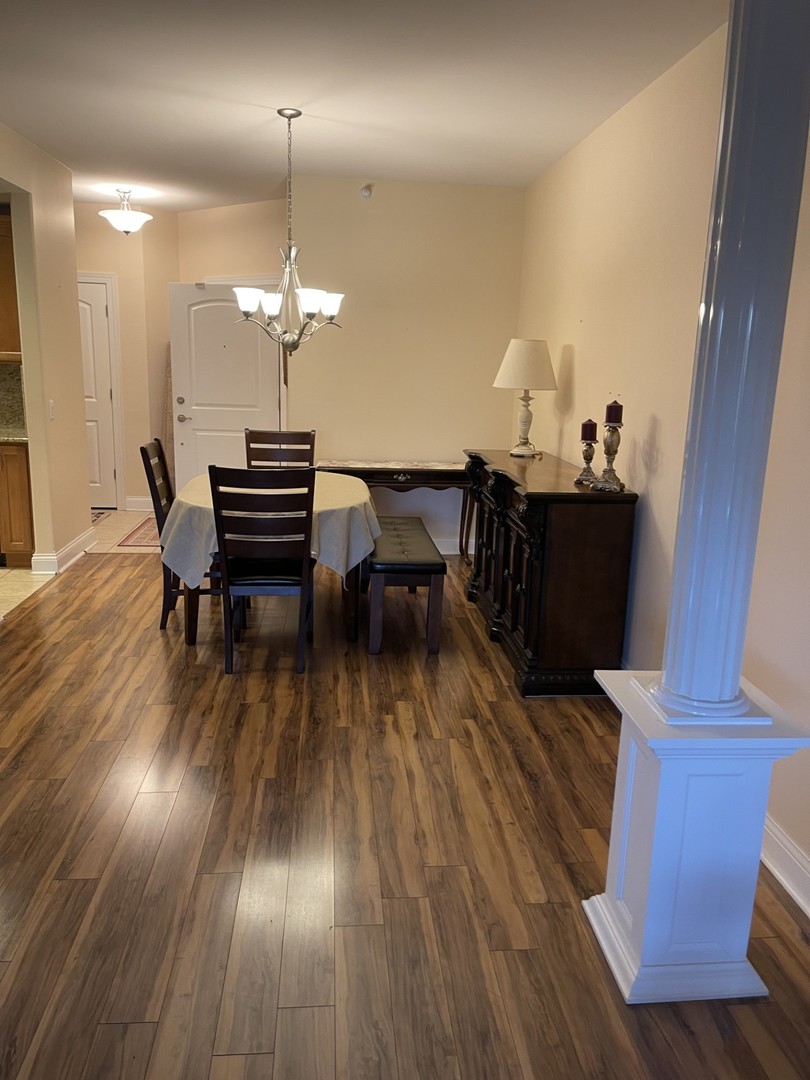 1210 Foxdale Drive, Unit 109 Addison, IL 60101 - Photo 11 of 29 a view of a dining room with furniture wooden floor and chandelier