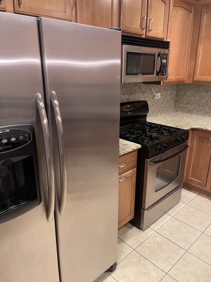 1210 Foxdale Drive, Unit 109 Addison, IL 60101 - Photo 13 of 29 a kitchen with granite countertop stainless steel appliances and wooden cabinets
