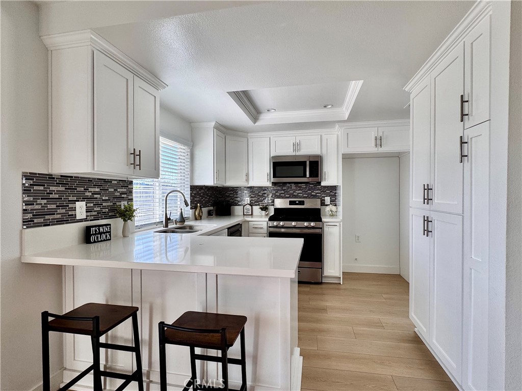 a kitchen with stainless steel appliances a stove a sink a microwave and a refrigerator