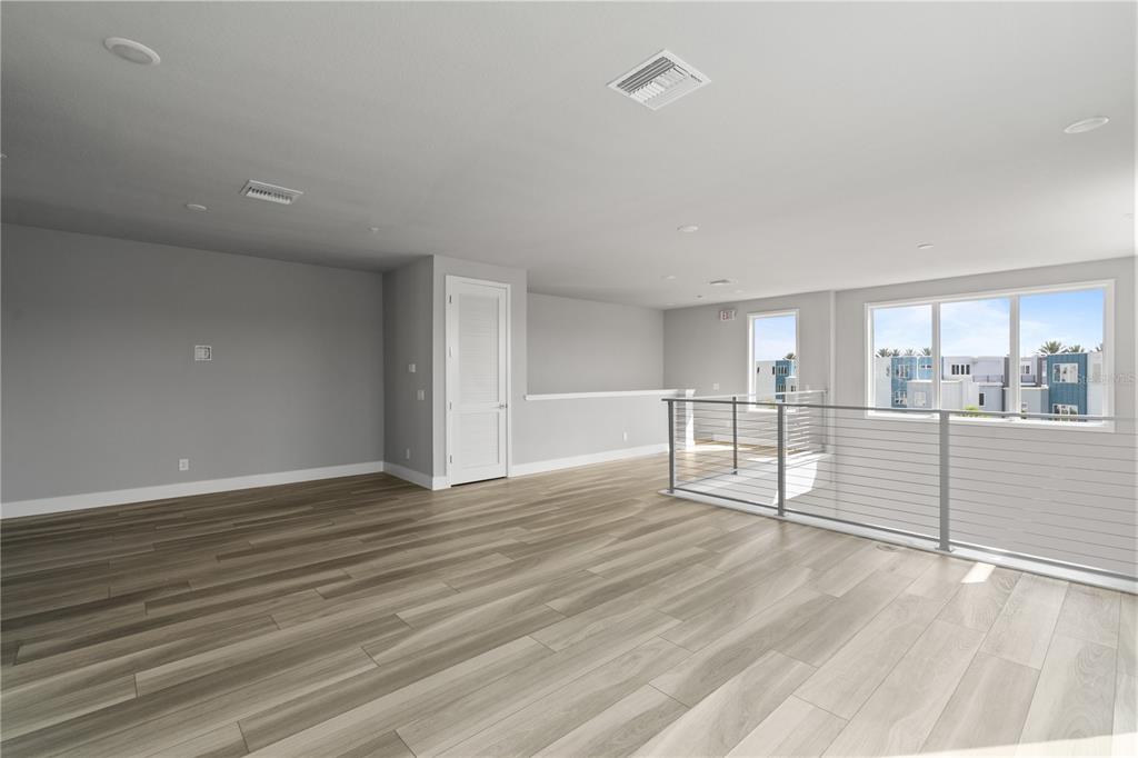 7770 Sandy Ridge Drive, Unit 239 Reunion, FL 34747 - Photo 19 of 49 a view of an empty room with wooden floor and a window