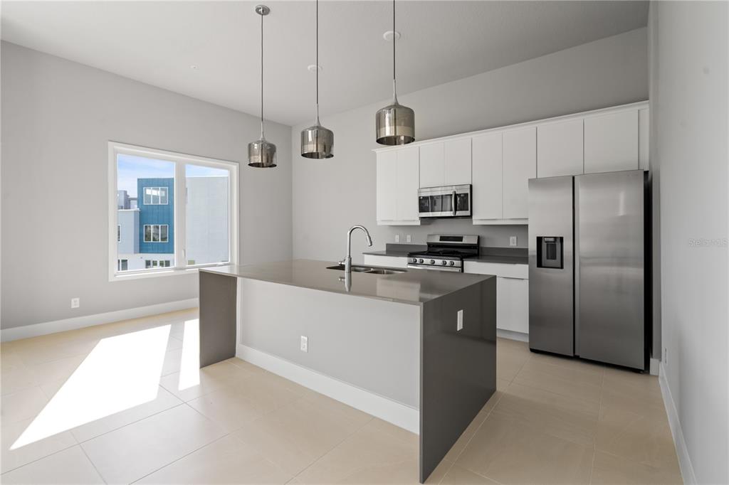 7770 Sandy Ridge Drive, Unit 239 Reunion, FL 34747 - Photo 2 of 49 a kitchen with stainless steel appliances a refrigerator a sink and white cabinets