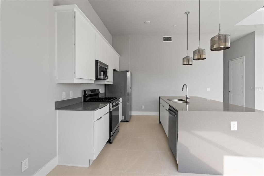 7770 Sandy Ridge Drive, Unit 239 Reunion, FL 34747 - Photo 3 of 49 a kitchen with stainless steel appliances a sink stove and refrigerator
