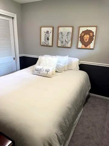a spacious bedroom with a bed and glass window