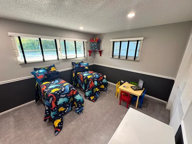 a bedroom with toys and a two windows