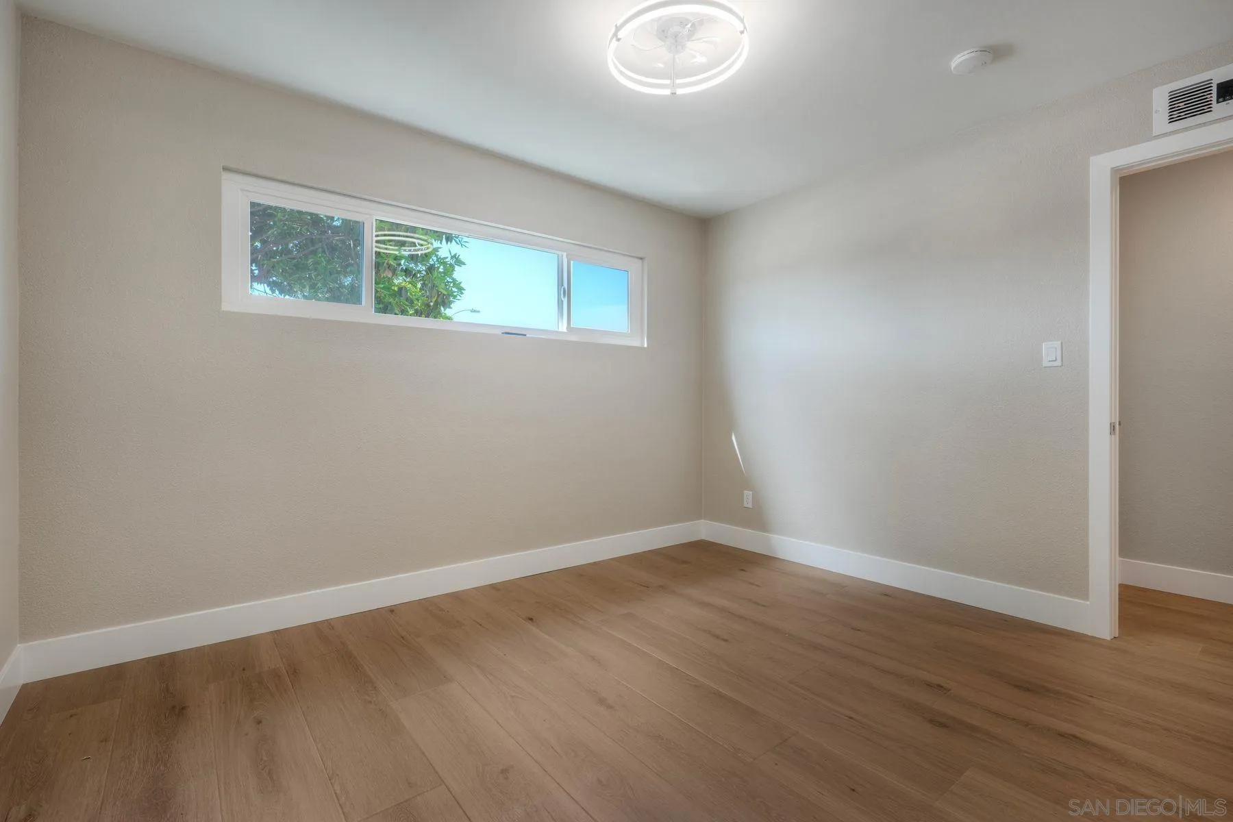 578 East Indian Rock Road Vista, CA 92084 - Photo 8 of 30 a view of an empty room with wooden floor and a window