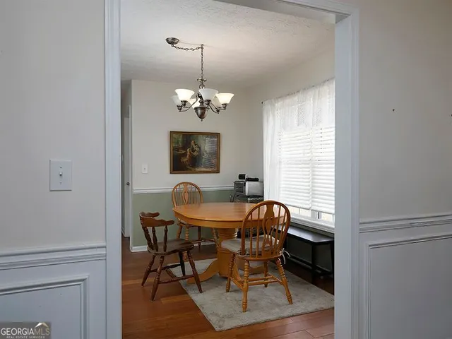 a dining room with furniture a chandelier and wooden floor
