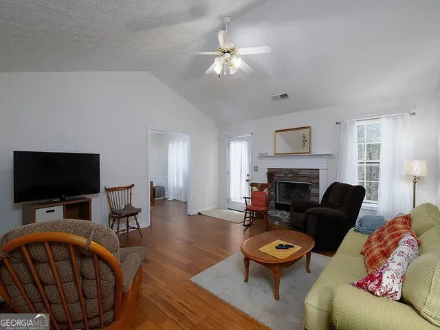 a living room with furniture a fireplace and a flat screen tv