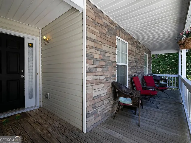 a view of a balcony with chairs and wooden floor