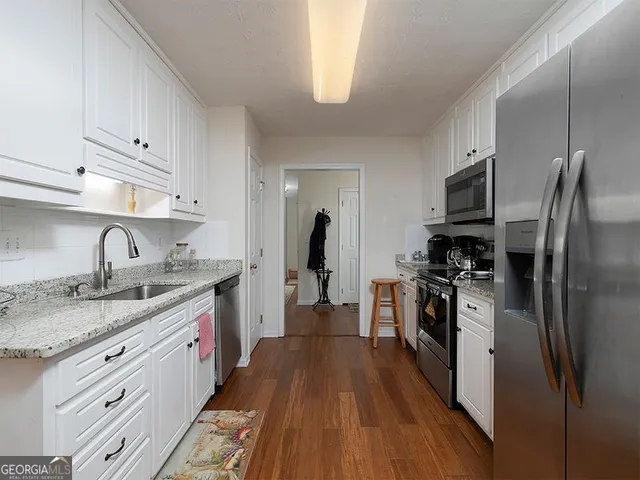a kitchen with stainless steel appliances granite countertop a refrigerator stove and sink