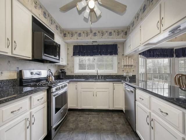 2N555 Beith Road Elburn, IL 60119 - Photo 9 of 22 a kitchen with stainless steel appliances granite countertop stove top oven a sink dishwasher and white cabinets with wooden floor