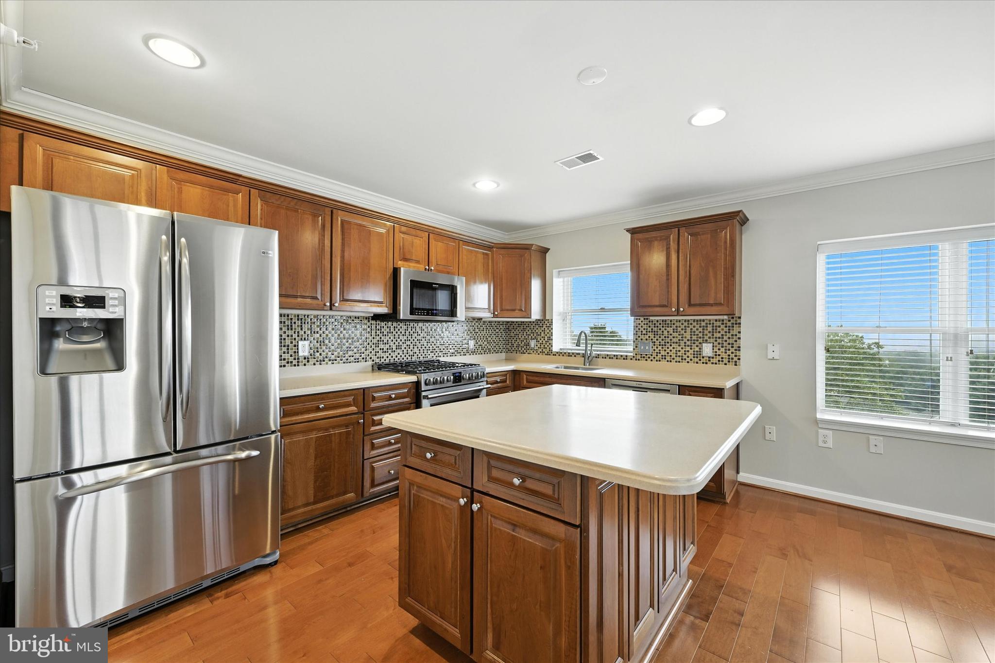 12240 Roundwood Road, Unit 808 Lutherville-Timonium, MD 21093 - Photo 11 of 31 a kitchen with stainless steel appliances granite countertop a refrigerator a sink dishwasher a stove and white countertops with wooden floor