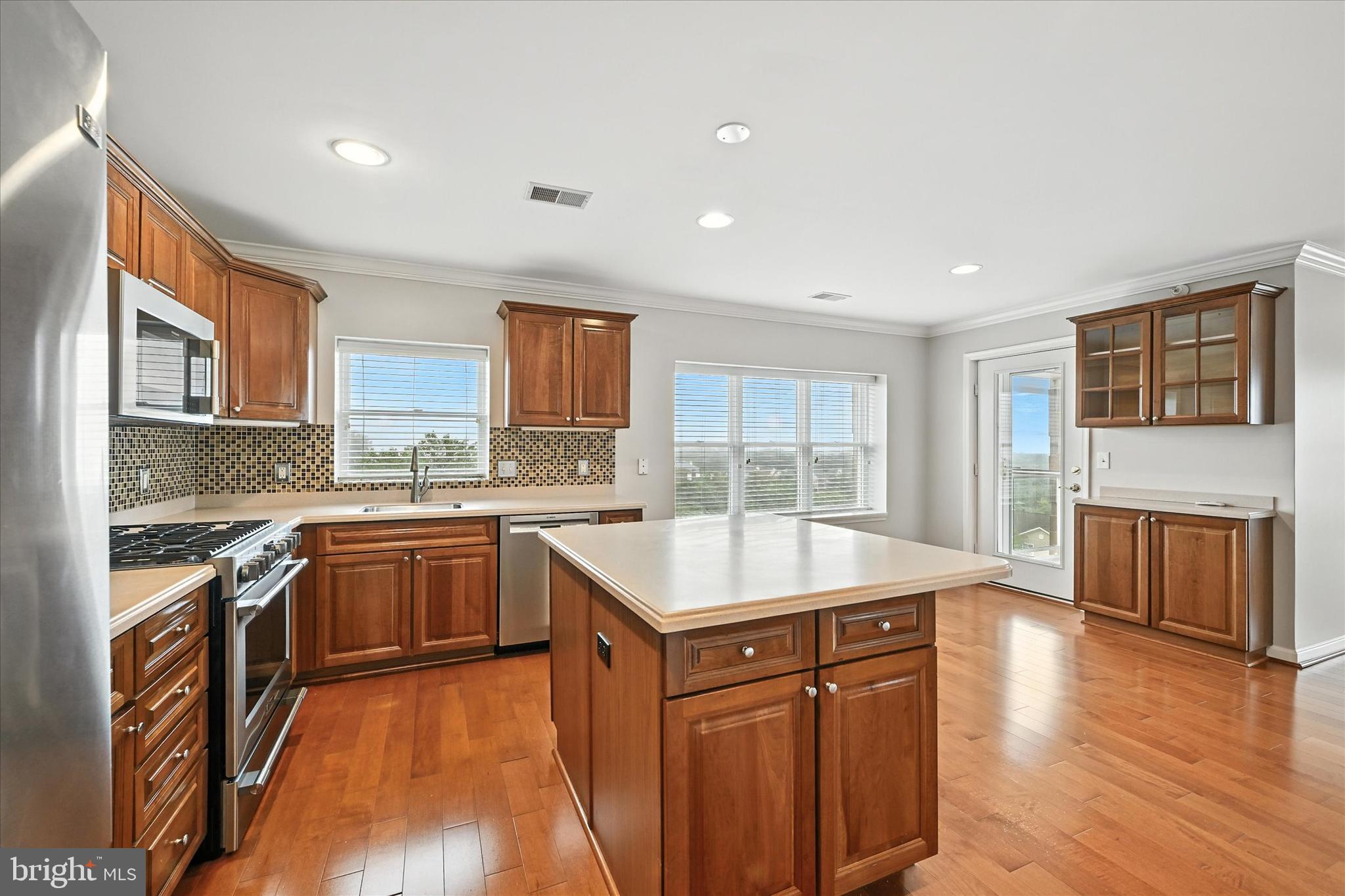 12240 Roundwood Road, Unit 808 Lutherville-Timonium, MD 21093 - Photo 12 of 31 a kitchen with a stove top oven sink and cabinets