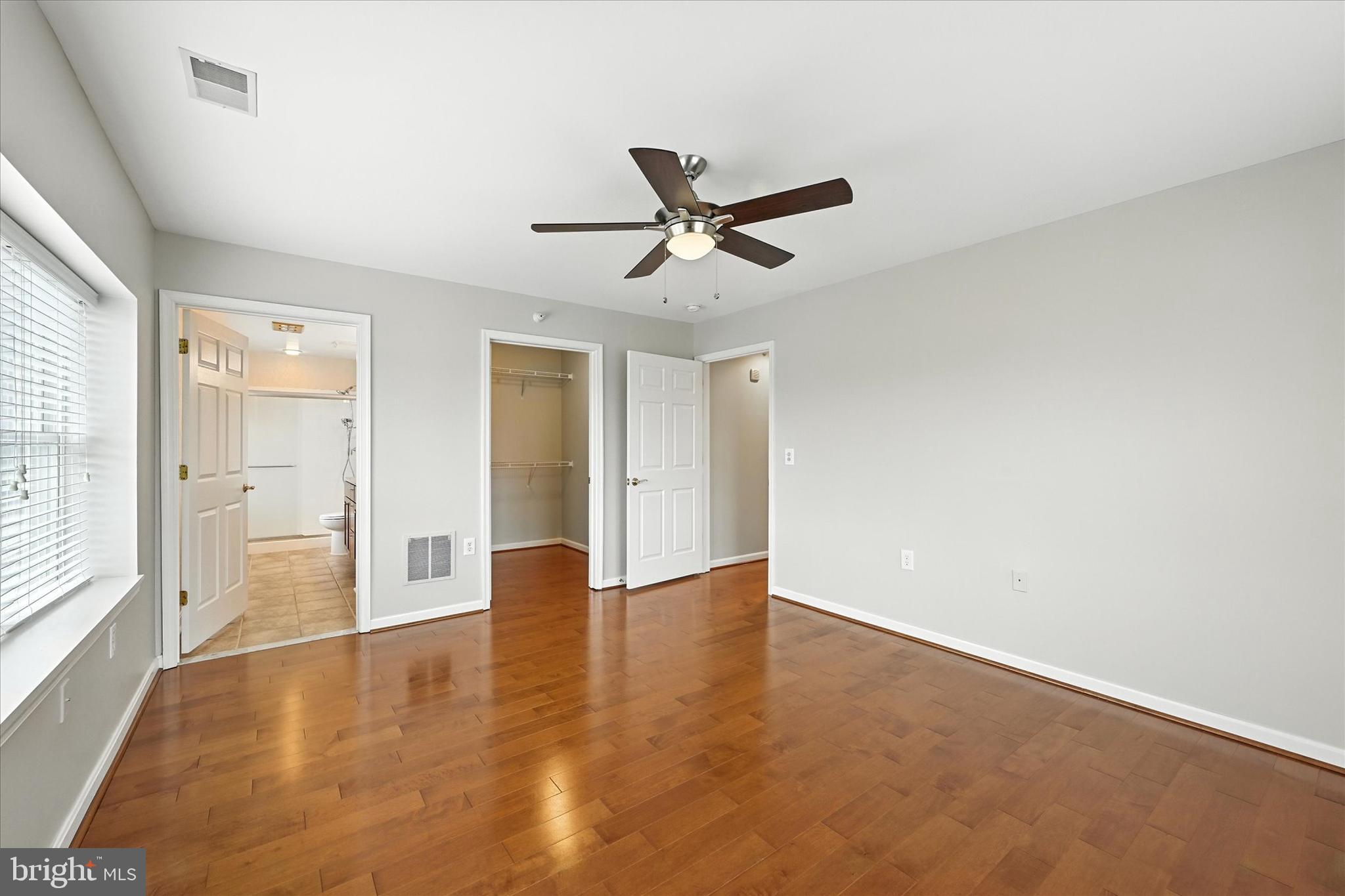 12240 Roundwood Road, Unit 808 Lutherville-Timonium, MD 21093 - Photo 23 of 31 an empty room with wooden floor and windows