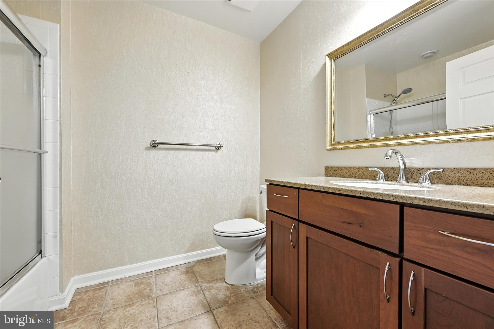 12240 Roundwood Road, Unit 808 Lutherville-Timonium, MD 21093 - Photo 27 of 31 a bathroom with a sink a toilet and a mirror