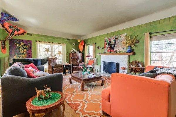 a living room with furniture a fireplace and a large window