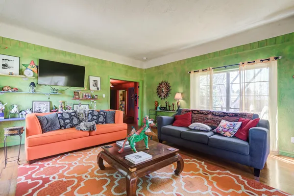 a living room with furniture a flat screen tv and a large window