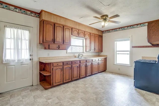 a large kitchen with stainless steel appliances granite countertop a large window a sink and cabinets