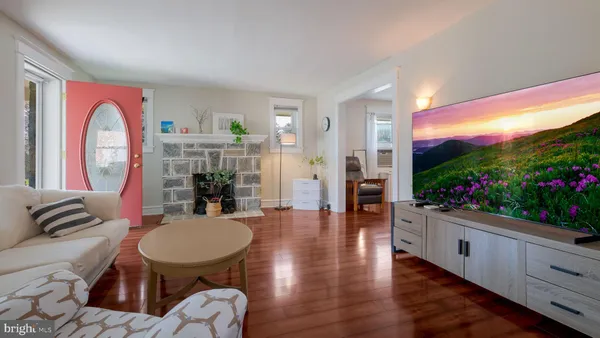 a living room with furniture a flat screen tv and a floor to ceiling window