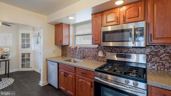 a kitchen with stainless steel appliances granite countertop a stove microwave and cabinets