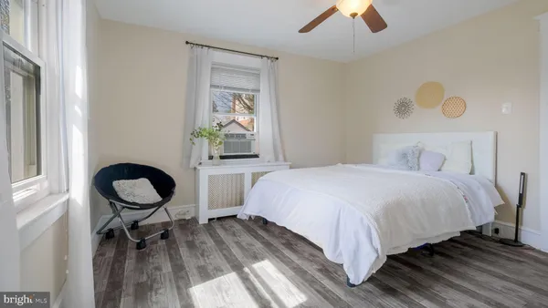 a large bed sitting in a bedroom next to a window and a chandelier