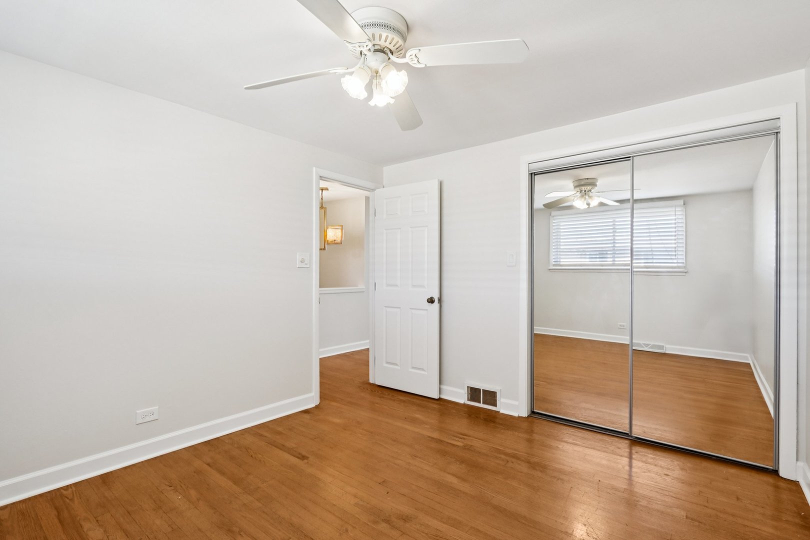 8666 Gregory Lane, Unit C Des Plaines, IL 60016 - Photo 11 of 30 an empty room with wooden floor and door