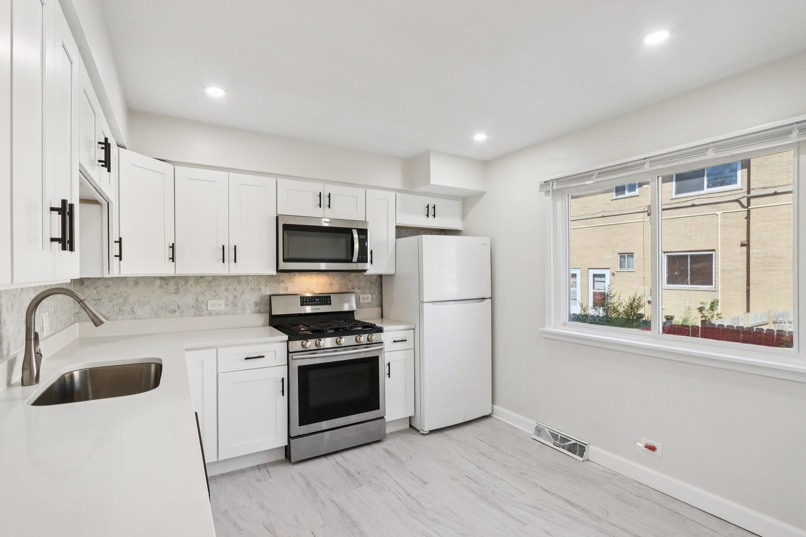 8666 Gregory Lane, Unit C Des Plaines, IL 60016 - Photo 6 of 30 a kitchen with a sink a stove a refrigerator and cabinets