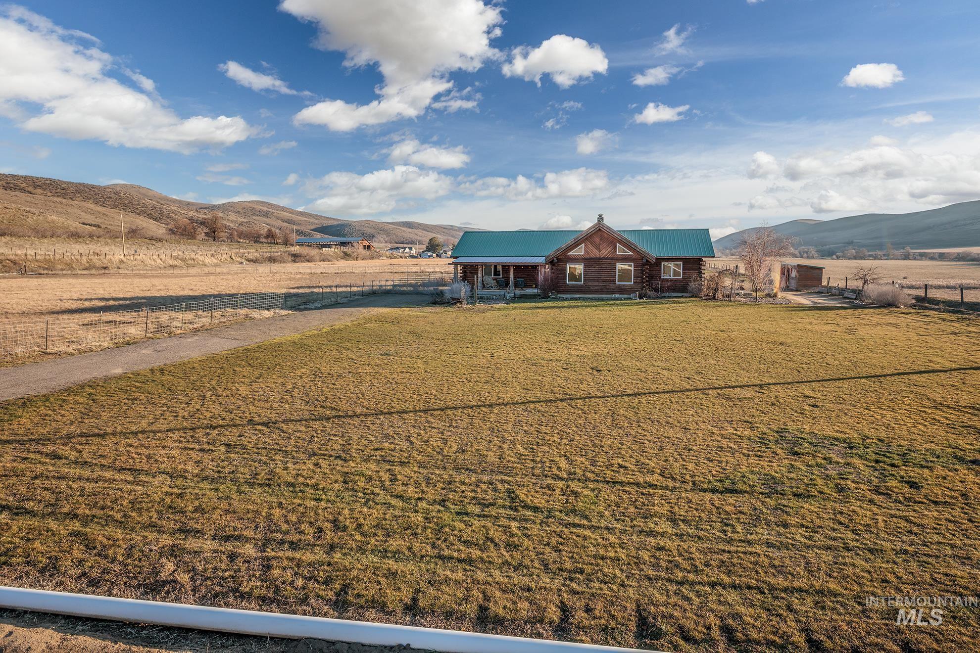 View of front facade with a mountain view, a view of rural / pastoral area, a metal roof, and covered porch