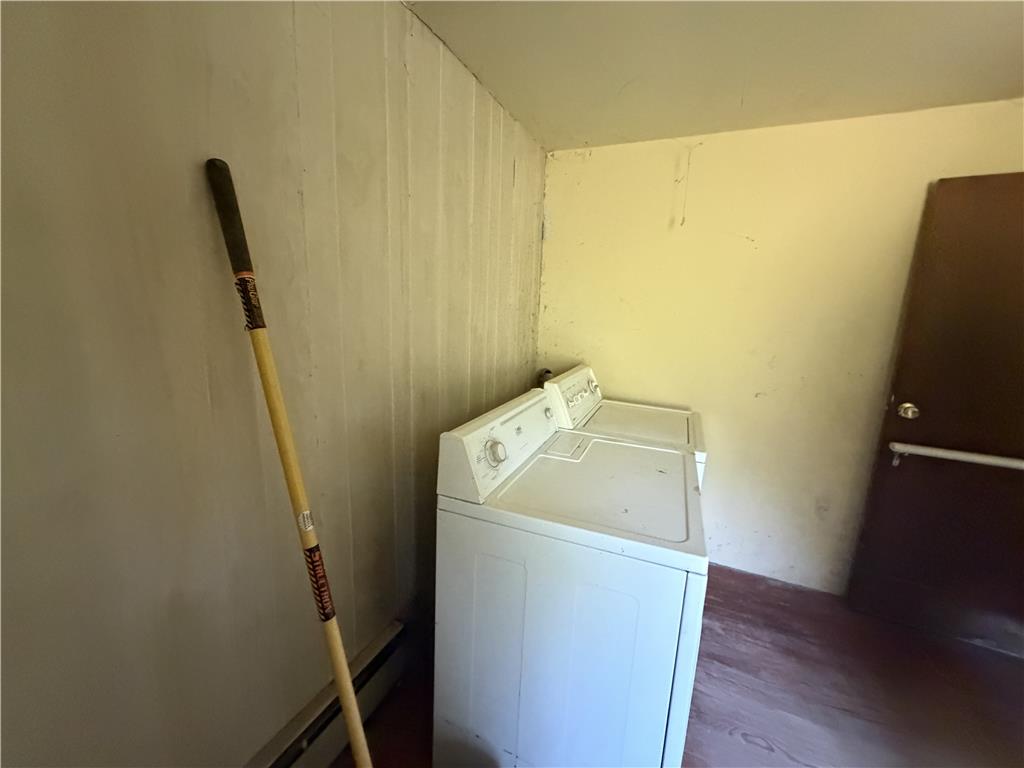 5114 Three Lakes Road New Milford, PA 18834 - Photo 35 of 55 A dedicated laundry space features wood paneling and direct exterior door access.